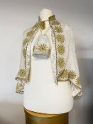 A white velvet cape with repeat sunshine medallion motif in gold cording and a matching drawstring