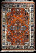 A 20th century hand knotted Persian area rug with central floral motif in gren, blue, orange and