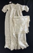 An early 20th century ivory silk christening gown and accompanying silk cloth / sash, both having