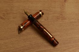 A mid 1920's Un Named lever fill fountain pen in Red ripple with single band to ring top cap