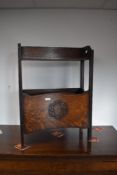 An early 20th Century oak paper/magazine rack, having shelf over double compartmented section,