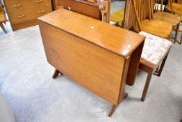A vintage teak G plan or similar gateleg dining table having whale tail like supports and a