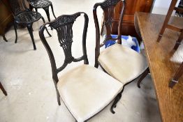 A set of four late 19th or early 20th Century dining chairs having overstuffed seats