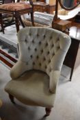 A modern nursing chair having button back green dralon upholstery