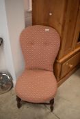A Victorian stained frame nursing chair having later upholstery