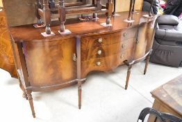 A reproduction Regency style mahogany serpentine front sideboard, width approx. 168cm