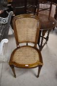 A reproduction French style dining chair having bergere cane back and seat