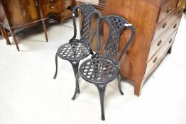 A pair of cast aluminium garden chairs