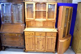 A vintage yellow pine kitchen dresser having part glazed upper section over triple drawer and