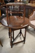 An early 20th Century oak twist gateleg hall/breakfast table forming half moon when closed and