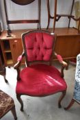 A reproduction continental style carver chair having button back and overstuffed seats