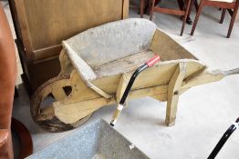 A vintage wooden wheelbarrow, width approx. 62cm, showing some signs of woodworm
