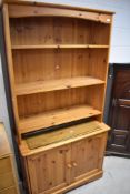 A modern pine kitchen dresser, having open shelves over double cupboard, width approx. 95cm