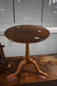A reproduction stained frame pedestal table having circular top and triple splay legs, diameter