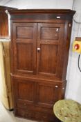 A 19th Century oak full height corner cupboard having upper and lower cupboards and two drawers to
