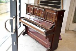 A late 19th or early 20th Century upright piano having overstrung action on metal frame, in mahogany