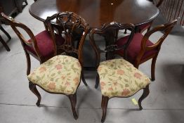 A pair of Victorian mahogany salon chairs having shaped backs and overstuffed seats