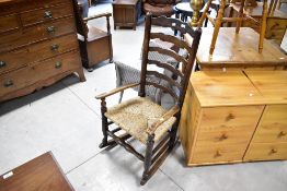 A 19th Century ladder back rocking chair having rush seat