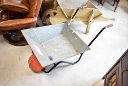 A traditional metal wheelbarrow , having ball style wheel
