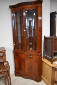 A reproduction Regency serpentine fronted full height display cabinet with drawer and cupboard to