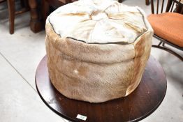 A vintage deerskin or similar pouffe