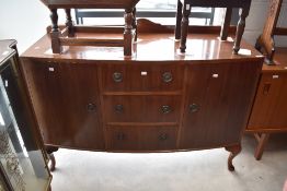 A reproduction Regency style sideboard, having three central drawers flanked by cupboards, on