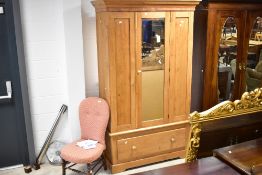 A Victorian stripped pine mirror door wardrobe having drawer base