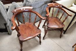 A pair of traditional stained frame elbow chairs