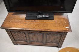 An early 20th Century oak bedding box having linen fold decoration to panels, dimensions approx.