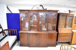 A nice quality reproduction mahogany breakfront bookcase having quadruple cupboards under,