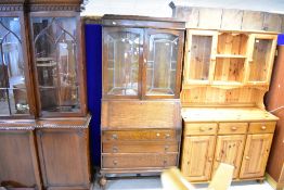 An early 20th Century oak bureau bookcase having lead glazed top with typical drop flap and