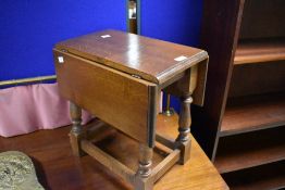 A reproduction oak drop leaf occasional table (coffin stool style) , approx. width 42cm