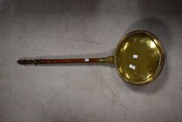 A traditional brass and copper warming pan