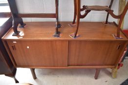 A vintage teak sideboard having twin sliding doors and recessed handles, possibly Fristho