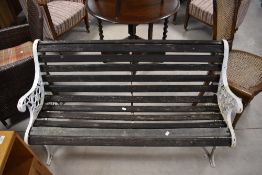 A traditional garden bench having cast ends and slatted seat, width approx. 127cm