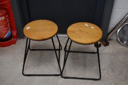 A pair of metal framed low stools or side table having circular wooden top, couple of small chips to