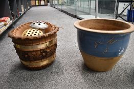 A large vintage stoneware jardinière, featuring light blue and tertiary detailing, with three