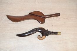 Two late 19th to early 20th-century carved wooden goose wing knitting sheafs, featuring a dark