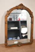 A late 19th to early 20th-century Rococo revival-style gilt-framed wall mirror, featuring ornate