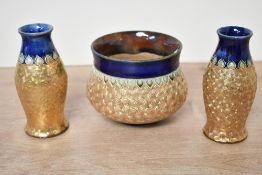 A late 19th to early 20th-century Royal Doulton stoneware small jardinière with two bud vases,