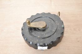An early 20th-century James Chesterman of Sheffield bakelite cased 50ft tape measure, featuring a