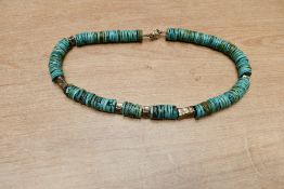 A statement silver and turquoise set necklace, the turquoise disks intersperesed by textured white