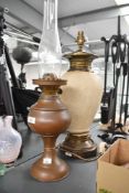 A early 20th-century copper oil lamp, having a rounded body and glass chimney; sold with a ceramic