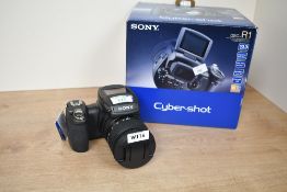 A Sony DSC-R1 Cybershot Digital camera with Carl Zeiss Vario Sonnar 2,8-4,8 14.7-71.5 lens boxed
