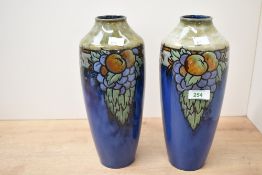 Two early 20th-century Royal Doulton Lambeth stoneware vases, featuring raised fruit and vine