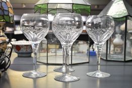 Four vintage Stuart Crystal 'Valencia' wine glasses, featuring geometric fan-cut panels around a