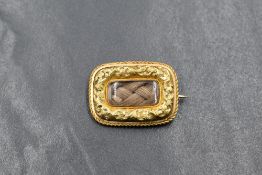 A yellow metal presumed gold hair mourning brooch, of rectangular form having a central hair
