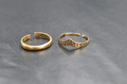Two broken gold rings, comprising a 9ct pierced wishbone ring and an 18ct gold band, marked 375