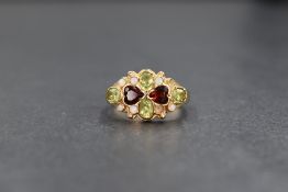 A 9ct gold peridot, opal and red paste set cluster ring, the two central heart cut red pastes in