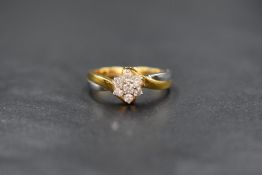 An 18ct gold diamond set floral cluster ring, the central round brilliant cut diamond in a six
